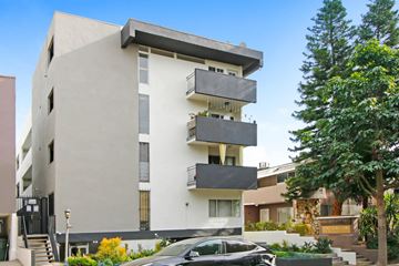 West Hollywood apartment for rent - A modern building with a car parked in front.