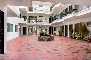 Los Angeles apartment for rent - A courtyard with a red tile floor and a fountain in the middle.