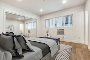 Los Angeles apartment for rent - A bedroom with a large bed and a mirror on the wall.