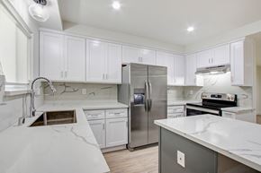 Los Angeles apartment for rent - A modern kitchen with white cabinets and a marble countertop.