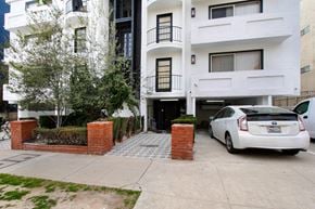 Los Angeles apartment for rent - A white car is parked in front of a white building.
