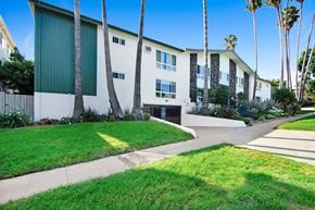 Los Angeles apartment for rent - A building with a green awning and a white wall with a window and a door.