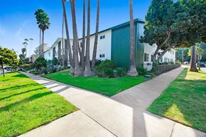 Los Angeles apartment for rent - A green building with a white fence and a green lawn in front.