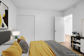Los Angeles apartment for rent - A bedroom with a bed covered in yellow and grey bedding.