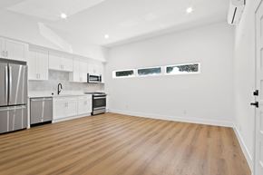 Santa Monica apartment for rent - A spacious kitchen with wooden floors and white cabinets.