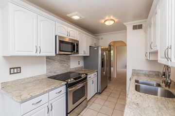 Sausalito apartment for rent - A kitchen with white cabinets and granite countertops.