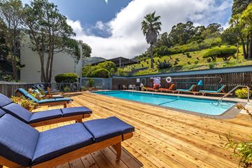 Sausalito apartment for rent - A pool with a wooden deck and lounge chairs.