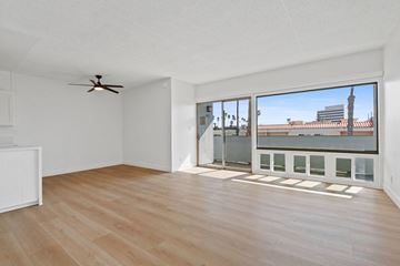 Santa Monica apartment for rent - A room with a ceiling fan and a large window overlooking a cityscape.
