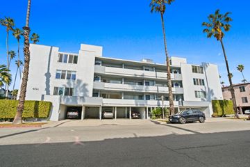 Santa Monica apartment for rent - A modern white building with palm trees in front.