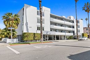Santa Monica apartment for rent - A white building with a palm tree in front of it.