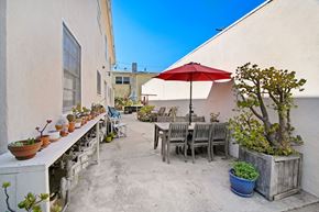 Santa Monica apartment for rent - A patio with a table, chairs, and a red umbrella.