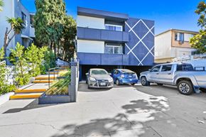 Los Angeles apartment for rent - A modern building with a blue car parked in front.