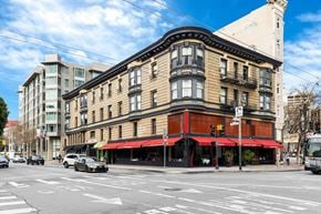 San Francisco apartment for rent - A street view of a city with a building in the foreground and cars on the road.