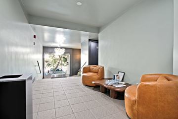 West Hollywood apartment for rent - A living room with a brown leather chair and a coffee table.