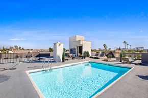 West Hollywood apartment for rent - A swimming pool in a backyard with a white building in the background.