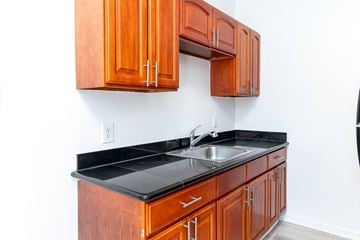 San Francisco apartment for rent - A kitchen with wooden cabinets and a black countertop.