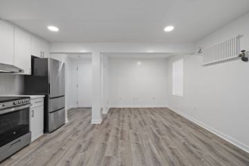 San Francisco apartment for rent - A kitchen with white cabinets and a black stove top oven.