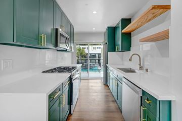 Los Angeles apartment for rent - A kitchen with green cabinets and white countertops.