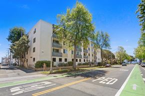 Santa Monica apartment for rent - A street view with a building, trees, and a bike lane.