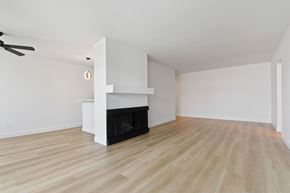 Santa Monica apartment for rent - A living room with a fireplace and a ceiling fan.