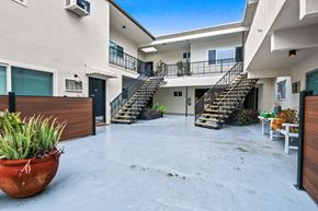 West Hollywood apartment for rent - A large outdoor patio area with a staircase leading to a balcony.