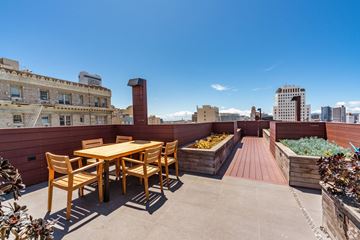 San Francisco apartment for rent - A wooden table and chairs are set up on a rooftop patio.