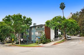 West Hollywood apartment for rent - A street view of a residential area with a blue building on the left and a white building on the right.