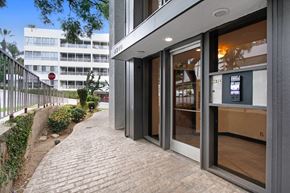 West Hollywood apartment for rent - A building with a glass door entrance and a brick pathway leading to it.