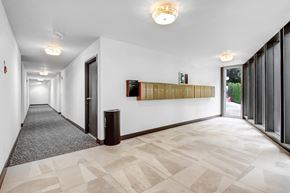 West Hollywood apartment for rent - A long hallway with a checkered floor and a wall with a picture on it.