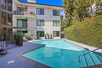 West Hollywood apartment for rent - A swimming pool in front of a white building with a balcony.