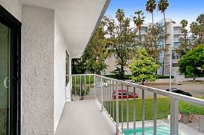 West Hollywood apartment for rent - A balcony with a white wall and a red car in the background.