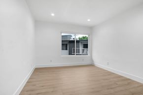 West Hollywood apartment for rent - A room with wooden flooring and a window showing a building outside.