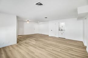 West Hollywood apartment for rent - A spacious room with wooden flooring and white walls.
