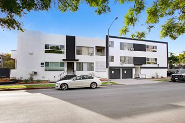 Los Angeles apartment for rent - A white car is parked in front of a modern two-story building.