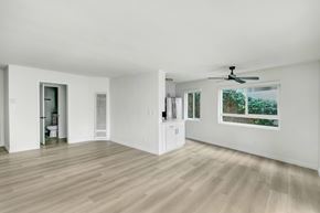 West Hollywood apartment for rent - A room with a ceiling fan and a window showing trees outside.