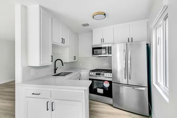 West Hollywood apartment for rent - A kitchen with white cabinets and stainless steel appliances.