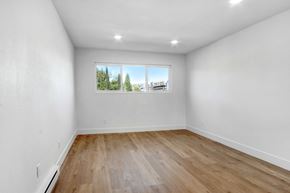 Los Angeles apartment for rent - A room with a window showing a view of trees and buildings outside.