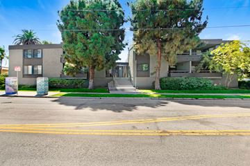 Los Angeles apartment for rent - A street view of a residential area with two houses, trees, and a clear sky.