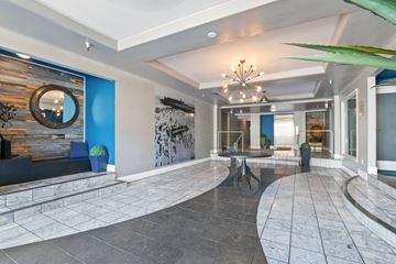 Santa Monica apartment for rent - A large, open living space with a stone floor and a chandelier hanging from the ceiling.