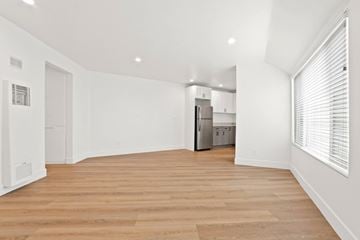 Venice apartment for rent - A kitchen with white cabinets and a wooden floor.