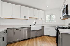 Venice apartment for rent - A kitchen with white cabinets and a wooden floor.