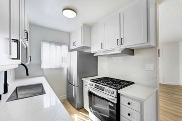 Venice apartment for rent - A modern kitchen with white cabinets and appliances.