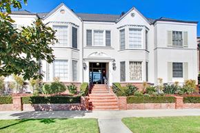 Beverly Hills apartment for rent - A white two-story house with a red brick staircase leading to the front door.