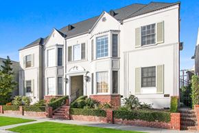 Beverly Hills apartment for rent - A white two-story house with a red brick wall in front.