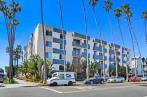 Santa Monica apartment for rent - A blue and white building with a USPS van parked in front.