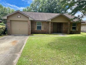 Pensacola house for rent - a brick house with a driveway and a garage door