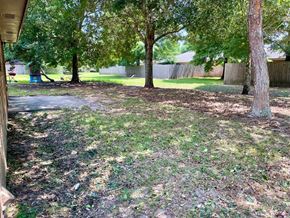 Pensacola house for rent - a backyard with trees and a cement walkway