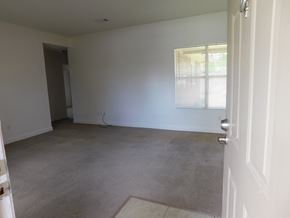 Pensacola house for rent - A room with a white door and a window with blinds.