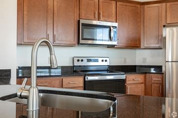 Harrisonburg apartment for rent - A kitchen with brown cabinets and a black countertop.