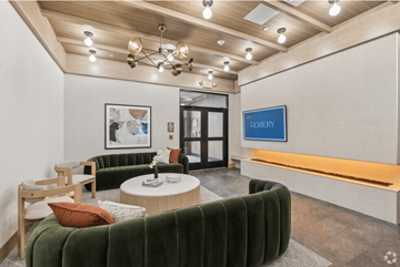 Lowell apartment for rent - A modern waiting room with a green velvet sofa and a coffee table.